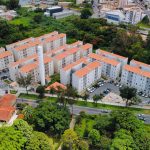Vista aérea de um complexo de apartamentos cercado por áreas verdes em Minas Gerais.