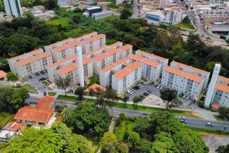 Vista aérea de um complexo de apartamentos cercado por áreas verdes em Minas Gerais.