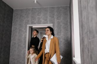 Família conversa com uma corretora durante a visita a um apartamento novo.