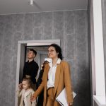 Família visita um apartamento com orientação de uma corretora de imóveis.